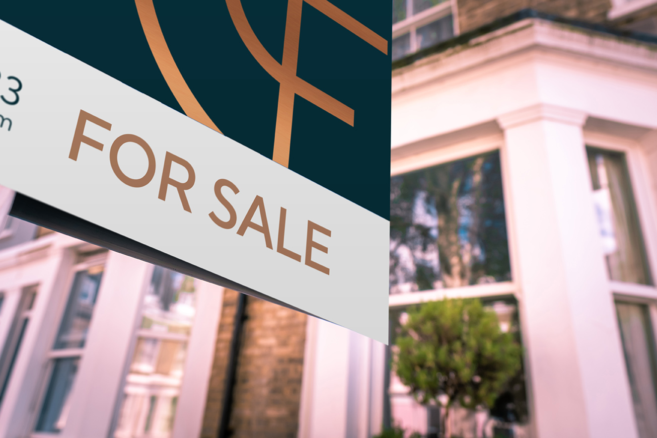 Image of a for sale board outside house.
